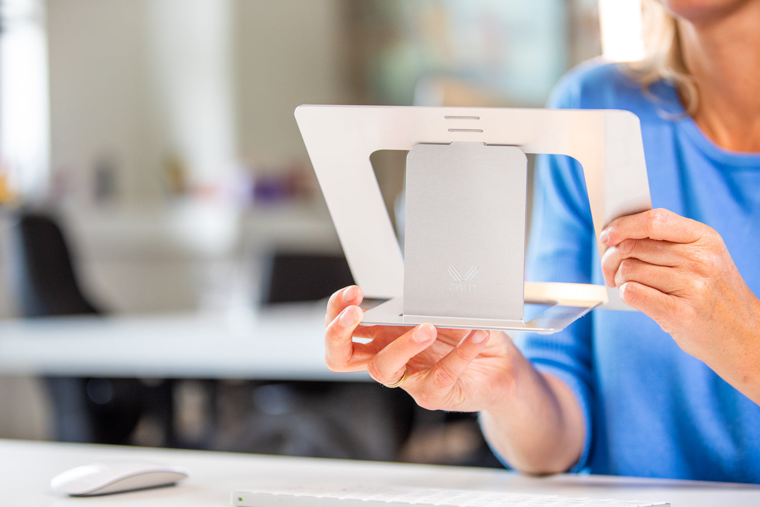 Vrouw met uitgevouwen, lichte OviStand laptopstandaard in hand